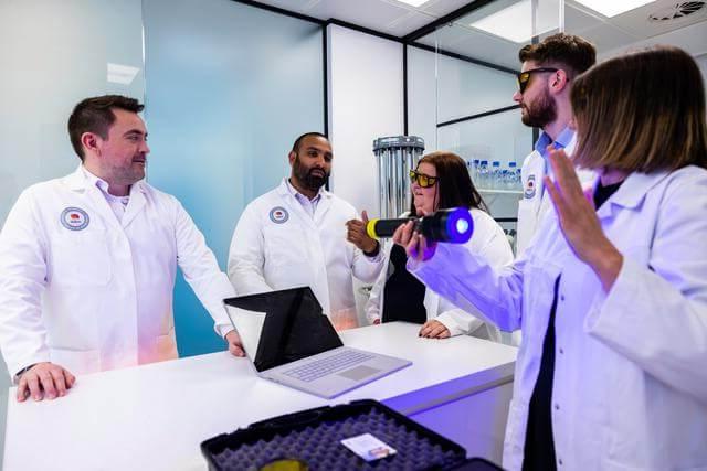 Mitie staff in a lab environment demonstrating UV cleaning techniques